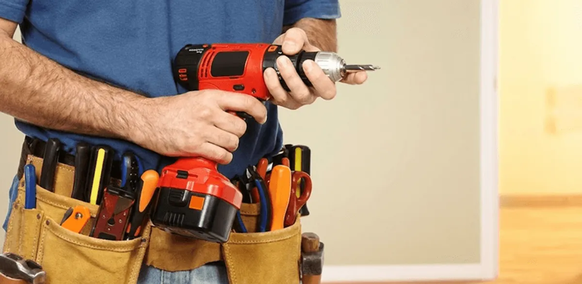 Handyman holding a power drill for home repairs and installations in Evansville, IN